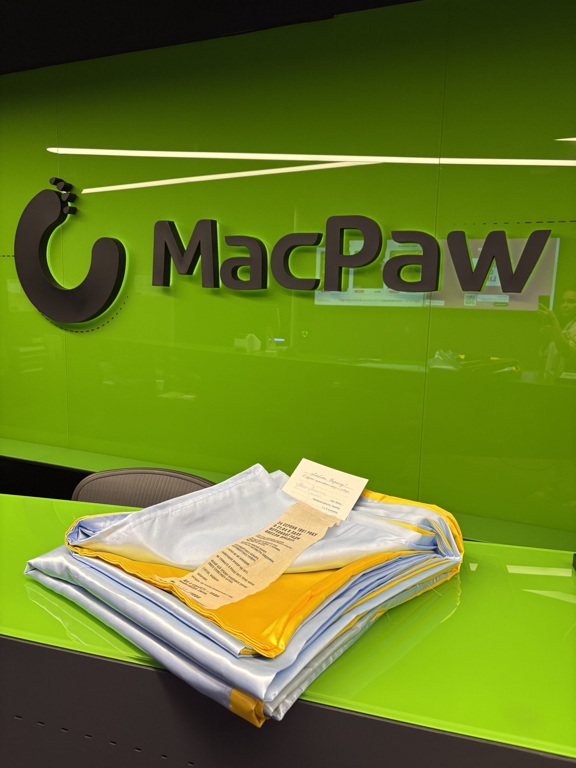 У серпні 2026-го MacPaw долучилася до проєкту «Прапор Незалежності» від Ukraine WOW і фонду «Повернись живим» до 35-ї річниці незалежності. Компанія придбала 4 екземпляри відтвореного прапора 1991 року й задонатила 120 000 грн на закупівлю наземних роботизованих комплексів для захисників — техніки, яку використовують для евакуації поранених і доставки вантажів без прямого ризику для людей.