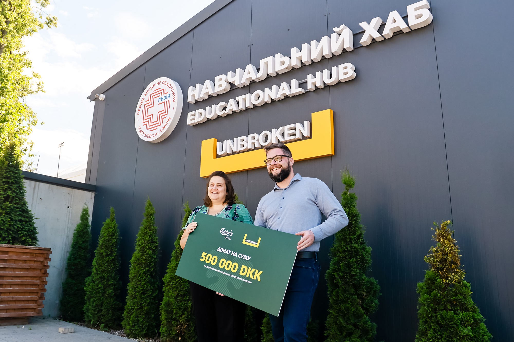 У липні 2026-го Carlsberg Group передала національному реабілітаційному центру UNBROKEN у Львові 500 тисяч данських крон — майже 3,5 млн грн — на освітні програми School of Medicine UNBROKEN University: навчання з невідкладної допомоги та симуляційний центр. Про донат заявив CEO Якоб Ааруп-Андерсен на данському фестивалі Folkemødet; новину опублікувала PJSC Carlsberg Ukraine.